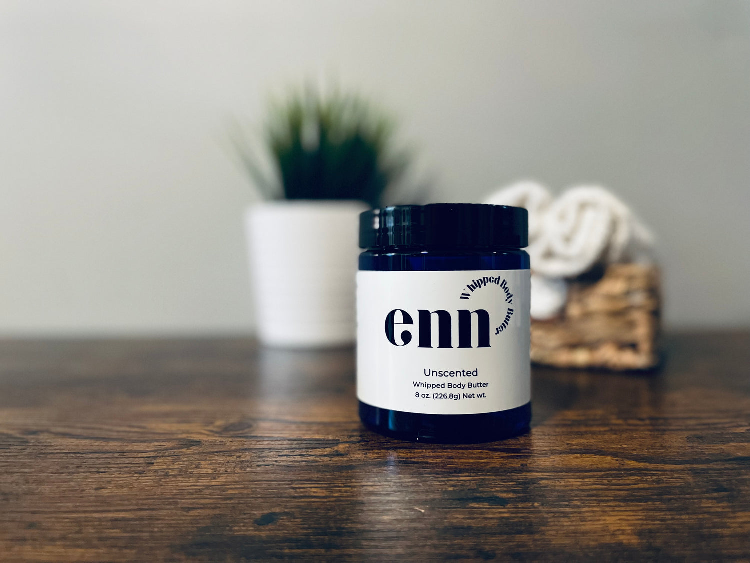 Unscented jar with greenery and white towels in the background